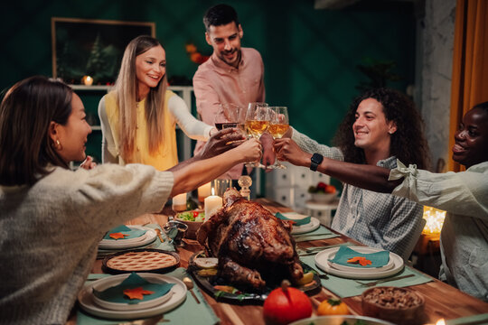 Friends toasting during thanksgiving dinner party at home