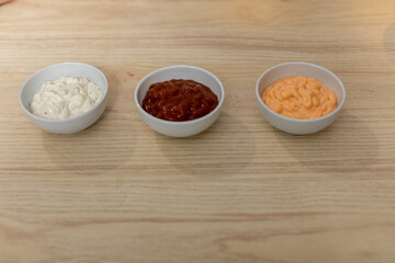 Three Distinct Varieties of Dipping Sauces Artistically Presented in Bowls for Enjoyment