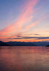 Naklejka premium Dramatic sunset over Lake Chelan with sky reflected in the smooth water of the lake in WA in long exposure photo