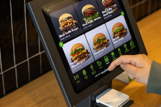 Tigard, OR, USA - Apr 26, 2025: Ordering burgers from a self-service kiosk at a Shake Shack restaurant in Tigard, Oregon. Shake Shack is an American multinational fast casual restaurant chain.