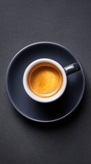 A rich espresso in a sophisticated dark gray cup and saucer sits atop a textured dark background.