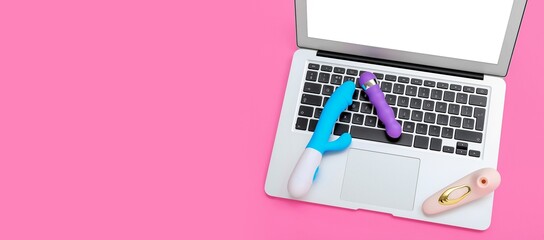 Laptop and vibrators from sex shop on pink background with space for text