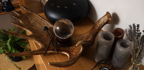 Moose antler with crystal ball, candles and glucophone on commode in witch's room