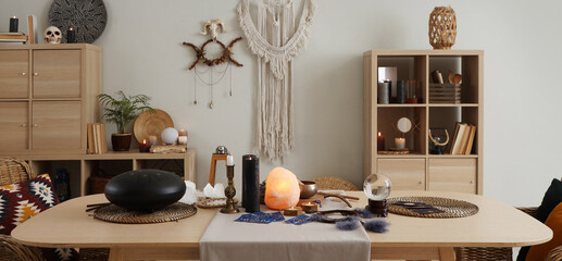 Interior of witch's room with magic attributes, table and shelf unit