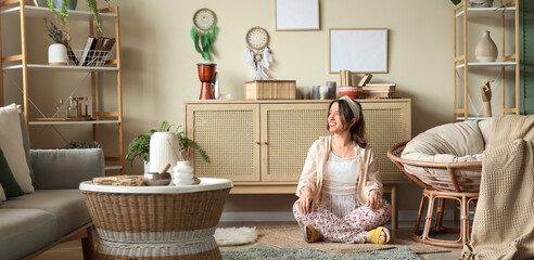 Young witch sitting on carpet at home