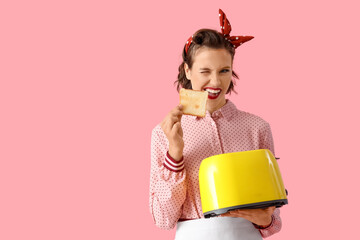 Beautiful young happy pin-up housewife with toaster and bread slice on pink background