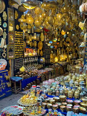 Shop full of handmade metal and ceramic products. Dozens of ornate brass lamps hang from the...
