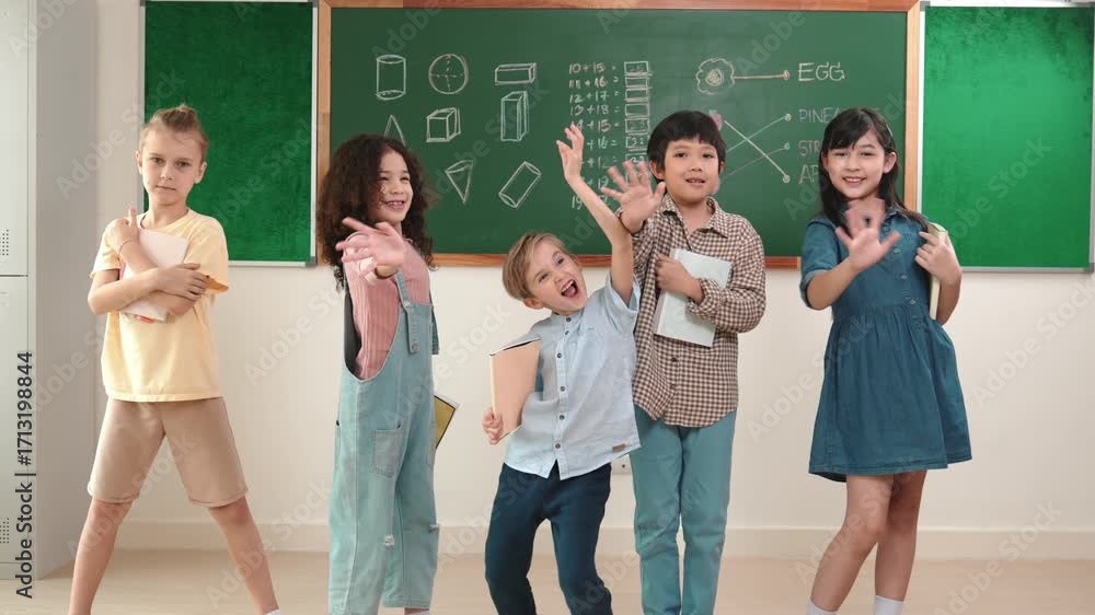 Poster multicultural elementary student in casual cloth looking at camera while waving hands at classroom. 