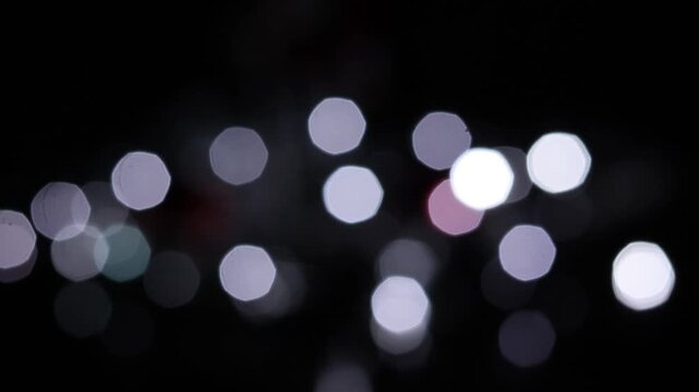 Una toma de cerca de luces de varios colores en forma de c&iacute;rculos en movimiento en la oscuridad. Desenfoque, efecto Bokeh. 