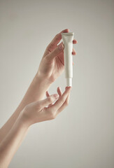 a woman holding cosmetics by the window