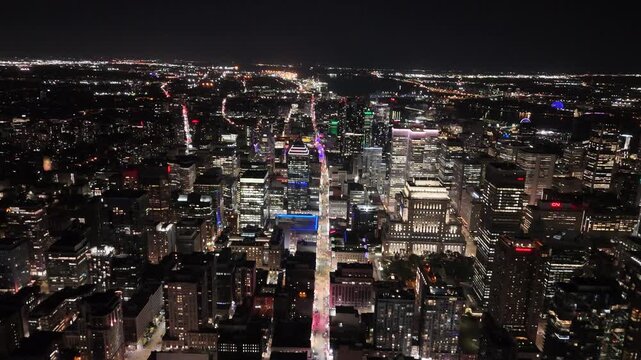 Drone moves at night toward the St. Lawrence River, capturing CIBC Tower, Sheraton, Scotiabank Tower, Old Port ferris wheel, and the rotating lights of 1000 de La Gaucheti&egrave;re