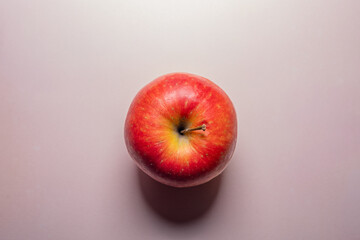 top down red apple on white pink background
