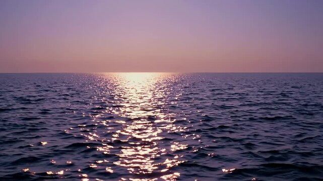 Serene ocean sunset with a wide-angle view, capturing the horizon's glow. Ideal for a calming video backdrop or peaceful scene setting.