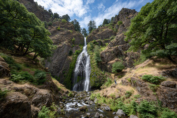 breathtaking summer landscape featuring oregon majestic waterfalls with solitary tourist standing below