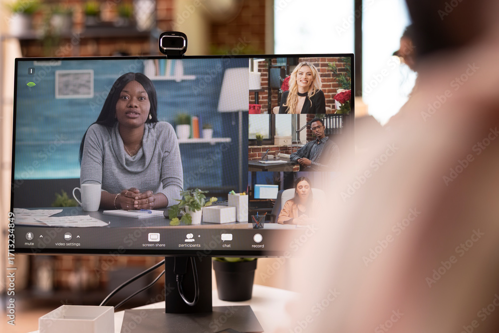 Poster remote financial advisor joins video call on desktop monitor, consulting with startup team from home