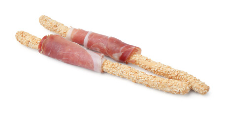 Delicious grissini sticks with sesame seeds and prosciutto isolated on white