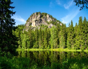 Rocky outcrop reflected in tranquil forest lake