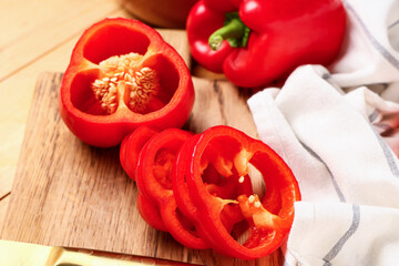 Cutting board with cut red bell pepper on wooden background, closeup