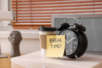 Paper with text BREAK TIME, alarm clock and coffee cup on folder in office, closeup