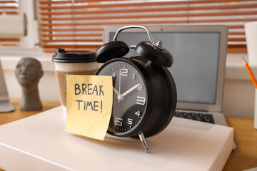 Paper with text BREAK TIME, alarm clock and coffee cup on folder in office, closeup