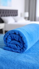 Rolled blue plush blanket on a surface in a bedroom