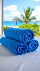 Rolled blue towels on a table with a beach view