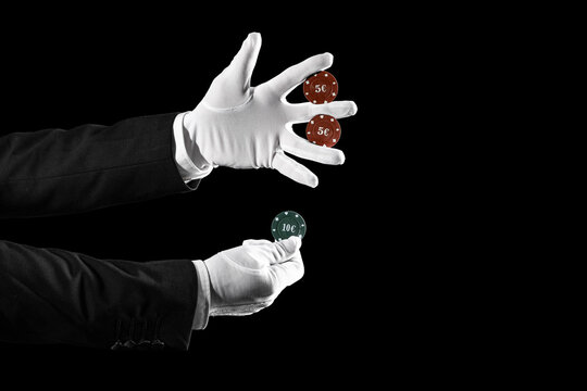 Male magician's hands with poker chips on black background