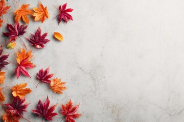 White surface with scattered autumn leaves, arranged in a minimalist seasonal design.