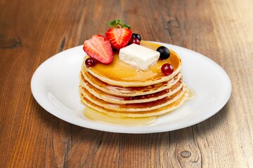 A stack of fluffy tasty sweet pancakes with syrup