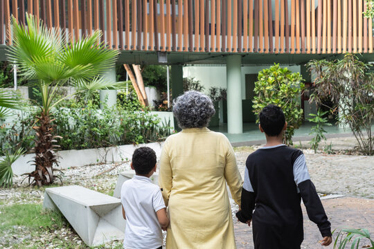Grandmother holding hands with grandchildren walking outdoors