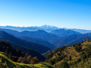 Obraz premium Majestic mountain range under a clear blue sky revealing layered hills and distant snow-capped peaks
