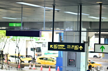 Guishan, Taiwan - Jul 21, 2025: Multi-directional wayfinding signage with left arrow to Chang Gung Hospital and right arrow to Wenhua 1st Road with taxis visible in background.