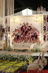 Luxurious Wedding Stage (Pelaminan) with Grand Floral Arrangements and Chandeliers