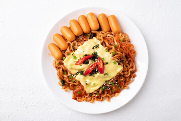 Top view of Korean spicy instant noodles with kimchi, sausage and Mozzarella cheese on white background