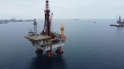 Offshore oil rig platform in the ocean, with a drilling derrick and support structures.