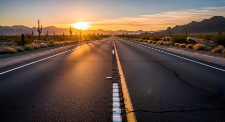 Fototapeta premium A long, empty highway stretches towards the horizon under a warm, golden sunset, with saguaro cacti dotting the desert landscape.