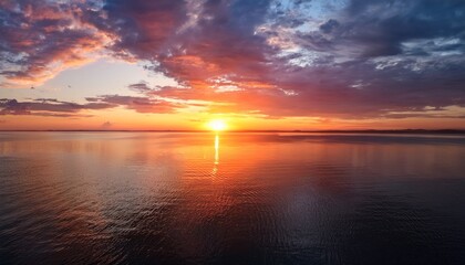 Fototapeta premium A Stunning Sunset Over Calm Waters With Vibrant Colors Illuminating The Sky