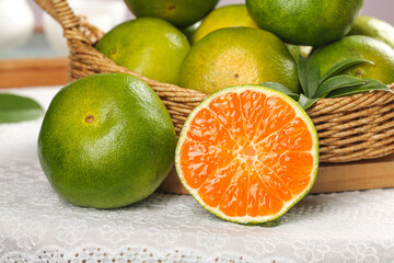 Fresh Green Citrus Tangerines with Orange Flesh in Wicker Basket - Healthy Vitamin C Rich Fruit