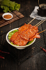 Grilled Pork Tenderloin Skewers with Fresh Ingredients and Dipping Sauce on Wooden Table