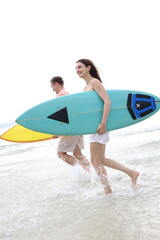 Couple lover running on beach with surfboards, splashing water and smiling under summer sunlight, concept of  friendship, vacation, holidays, surfing, freedom, and fun tropical lifestyle.
