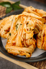 Steamed Pork and Scallion Rolls with Hand-Made Pastry Layers on Dark Plate