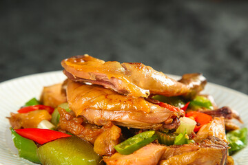 Stir-fried chicken with bell peppers and onions on white plate - Asian cuisine specialty dish