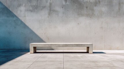 Minimalist concrete bench against a weathered wall with strong sunlight and shadow.