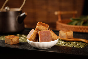 Handmade Brown Sugar Cubes in White Bowl on Rustic Kitchen Counter with Vintage Cooking Utensils