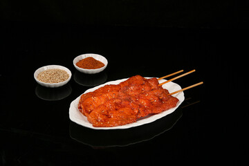 Grilled Meat Skewers with Spices and Sesame Seeds on Black Background