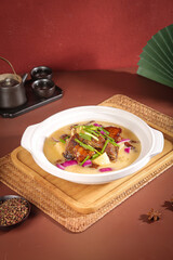 Asian Roasted Duck Soup with Soy Sauce and Scallions on Bamboo Plank - Traditional Chinese Cuisine