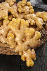 Fresh Ginger Root from Yunnan Fujian China in Wicker Basket on Wooden Table