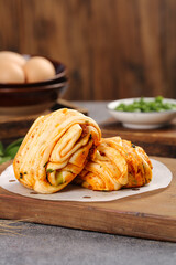 Homemade artisan scallion meat rolls with succulent filling on rustic wooden board