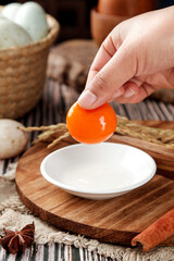 Fresh Farm Duck Egg with Bright Orange Yolk Being Cracked in Rustic Kitchen