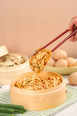 Handmade Steamed Scallion Pancake Rolls with Meat Filling in Bamboo Steamer and Chopsticks